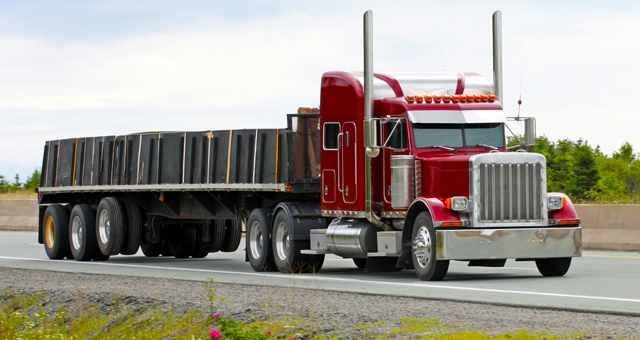 A flatbed trailer loaded with open-deck freight